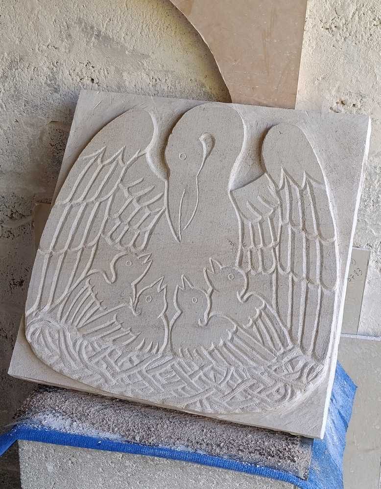 sculpture d'un pelican en pierre en bas-relief en cours